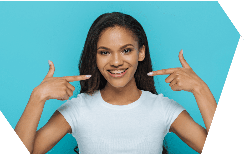 girl smiling with braces pointing to teeth