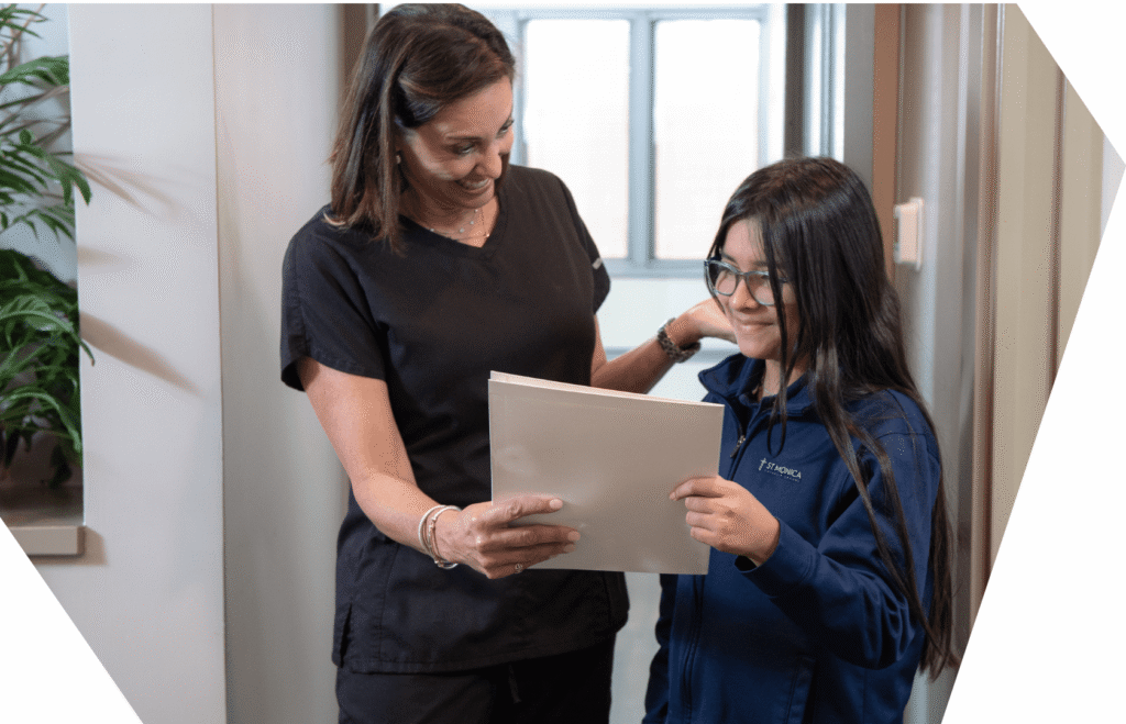 A Werner Orthodontics team member going through a treatment folder with a young patient