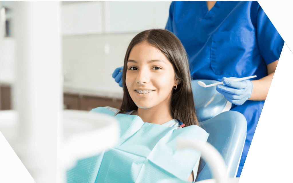 A young patient with braces smiling in the treatment chair