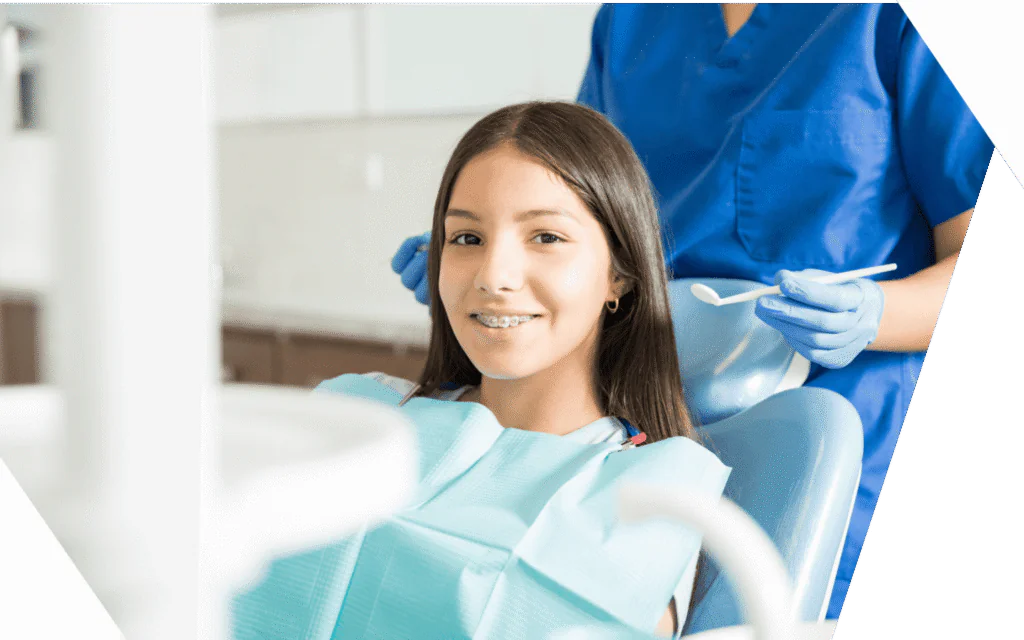 A young patient with braces smiling in the treatment chair